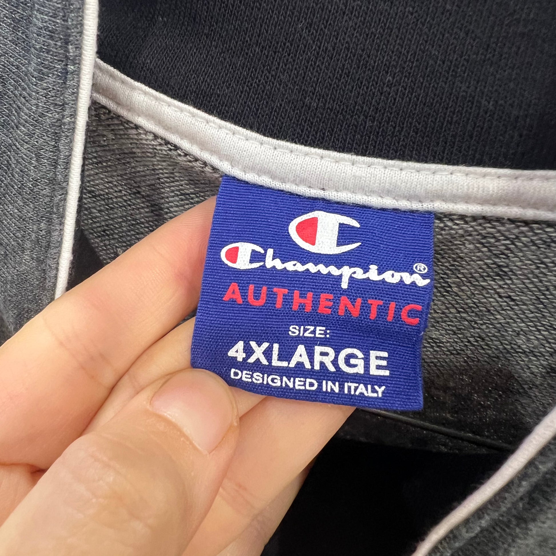 Champion authentic label on a garment with a hand holding it