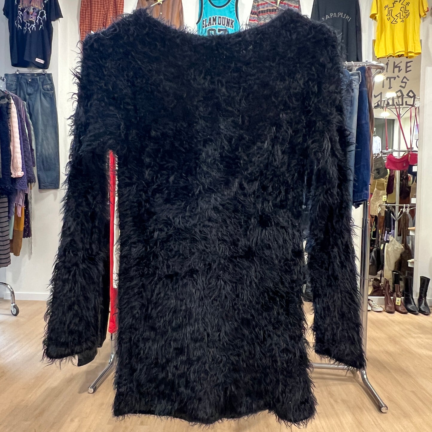 Black fluffy coat on a rack in a clothing store