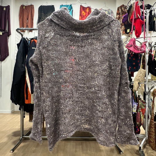 Gray textured sweater on a hanger in a clothing store setting