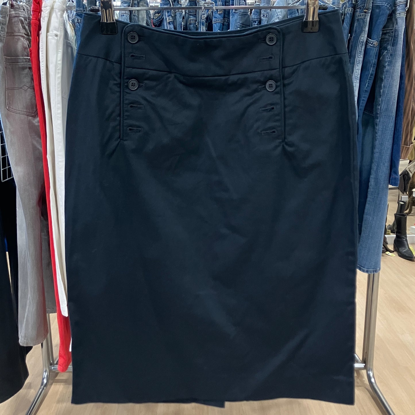 Black skirt hanging on a rack with other clothing items