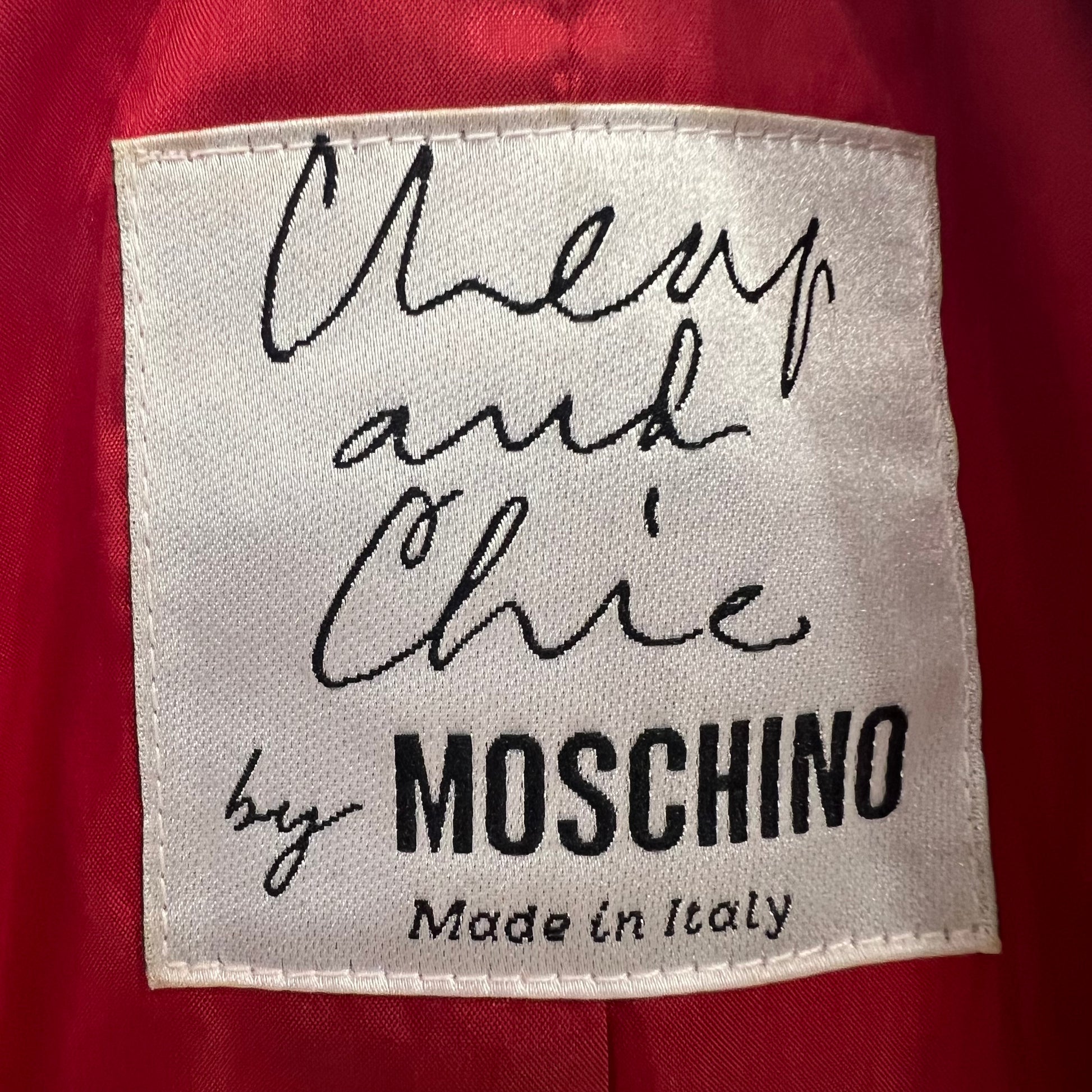 Label with 'Cheap and Chic by Moschino Made in Italy' text on a red background