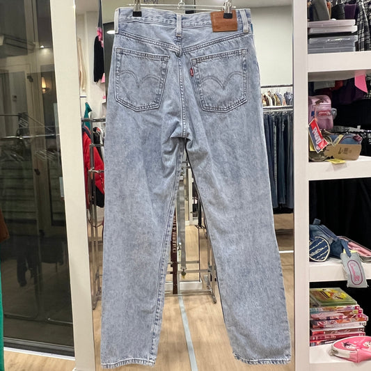Light blue jeans hanging on a rack in a store setting