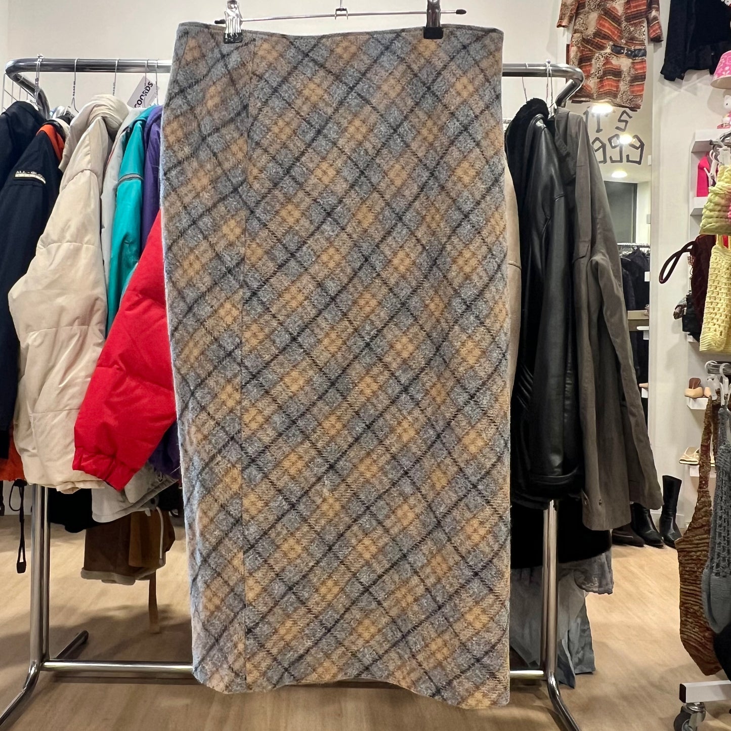 Plaid skirt on a rack with clothing in the background