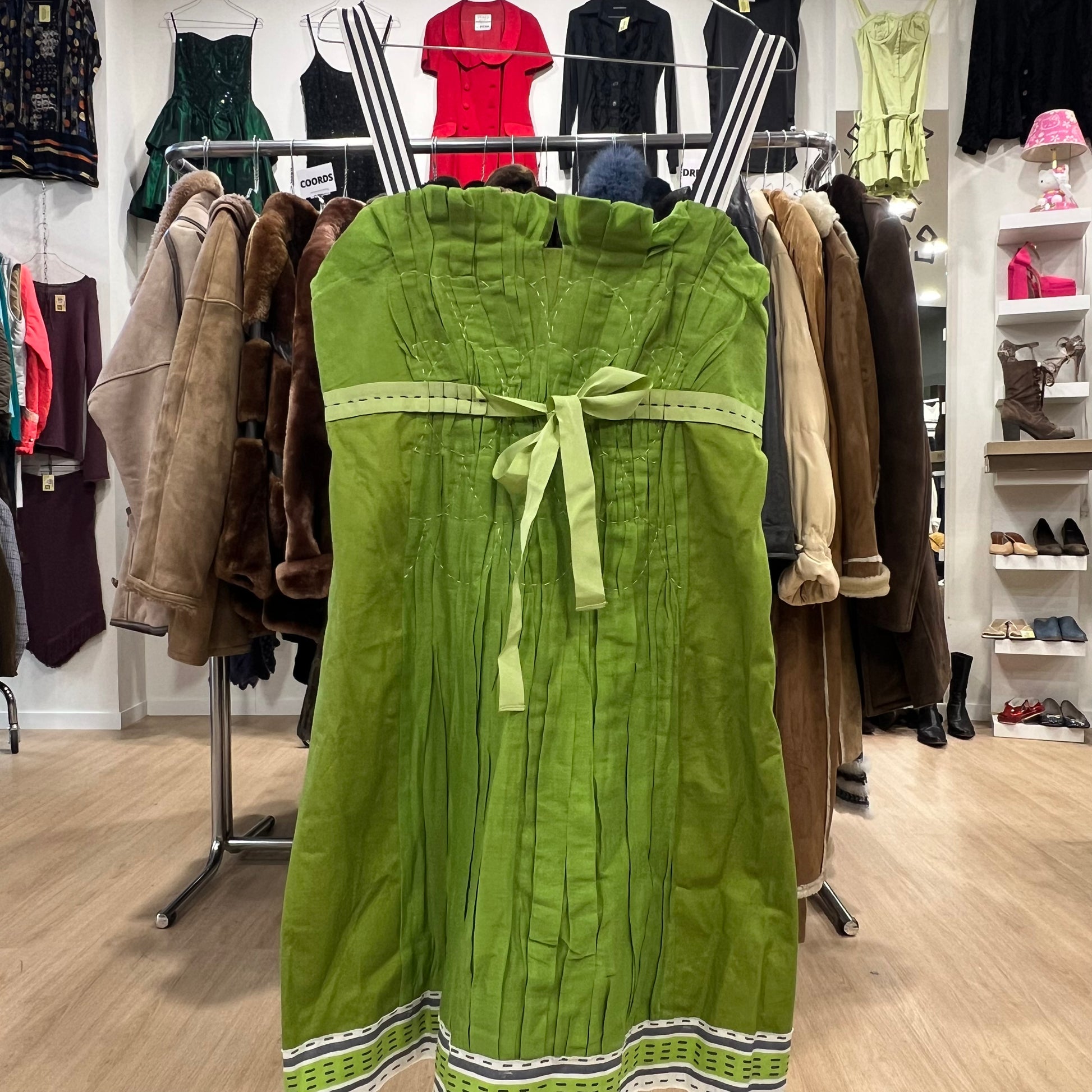 Green dress with a bow on a rack in a clothing store