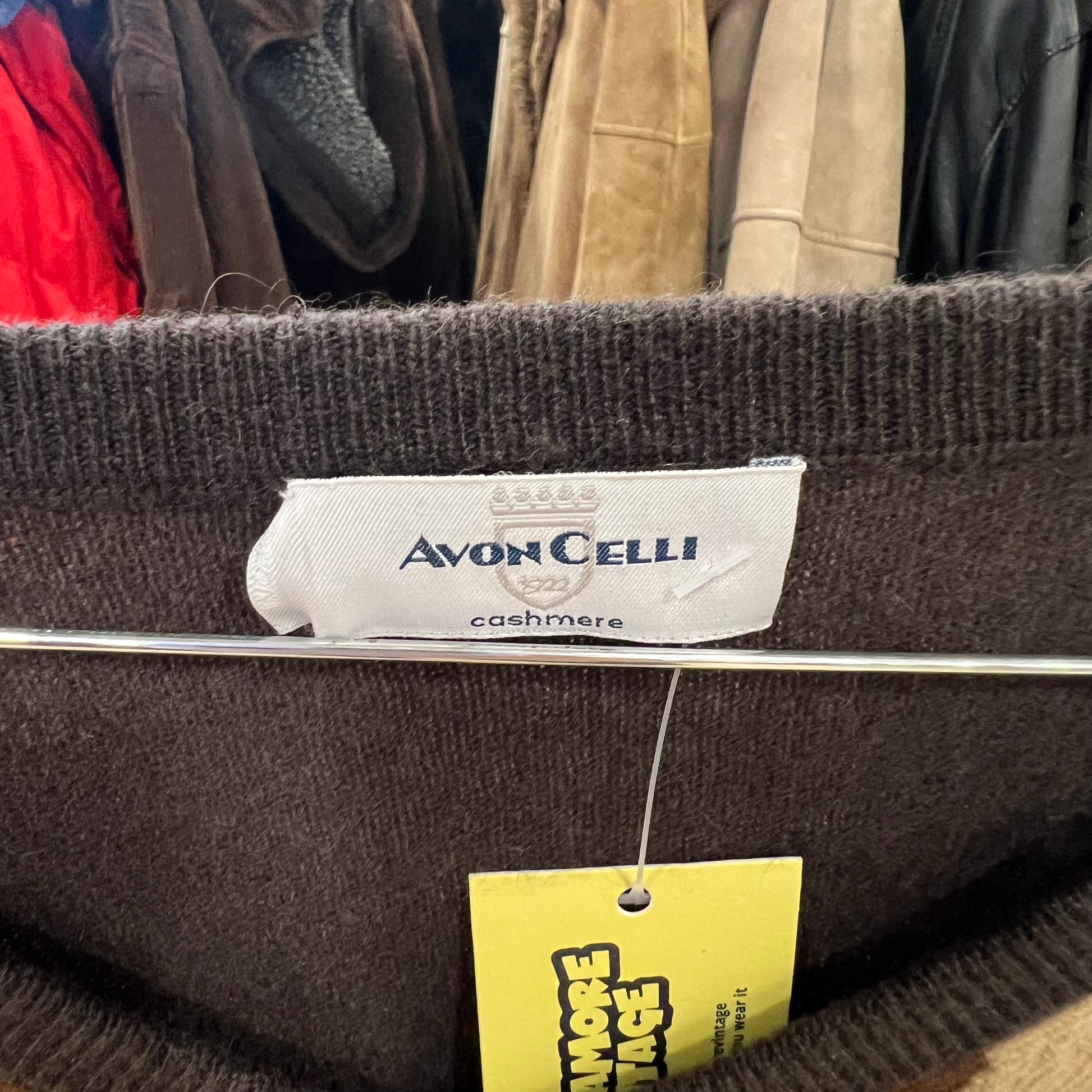 Brown cashmere sweater with Avon Celli label and yellow tag in a clothing store setting
