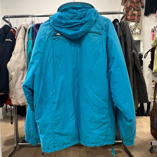 Blue puffer jacket on a rack in a store setting with other clothing items