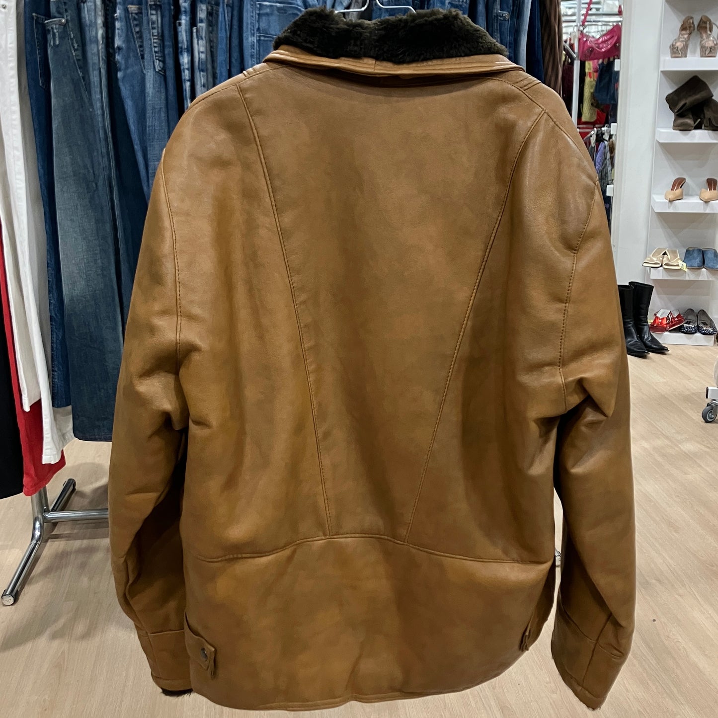 Brown leather jacket in a clothing store setting