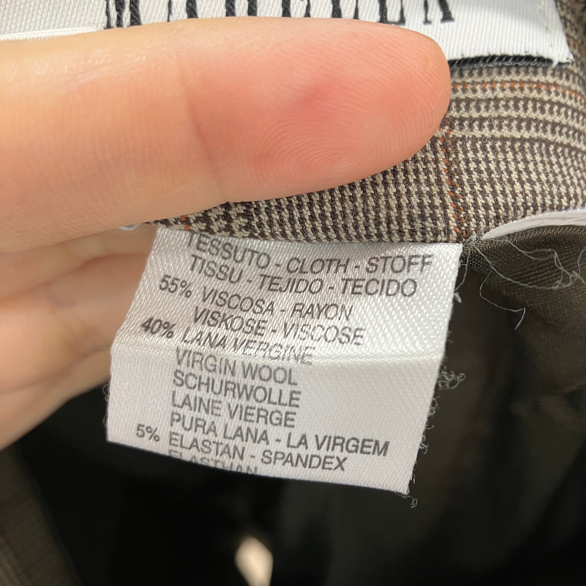 Clothing label with fabric composition details held by a hand