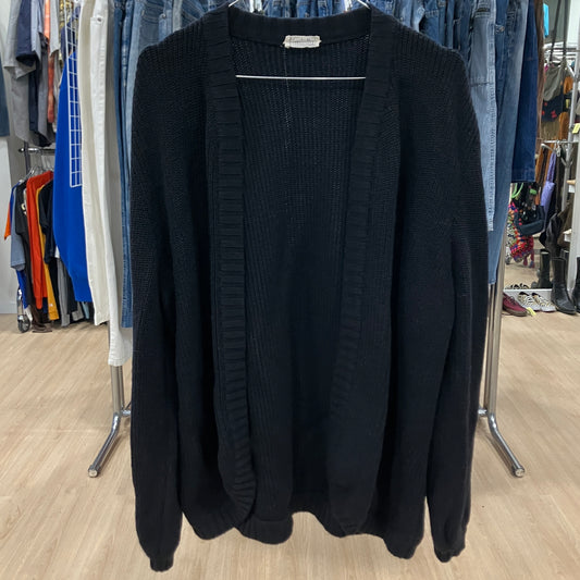 Black cardigan hanging on a rack in a store setting
