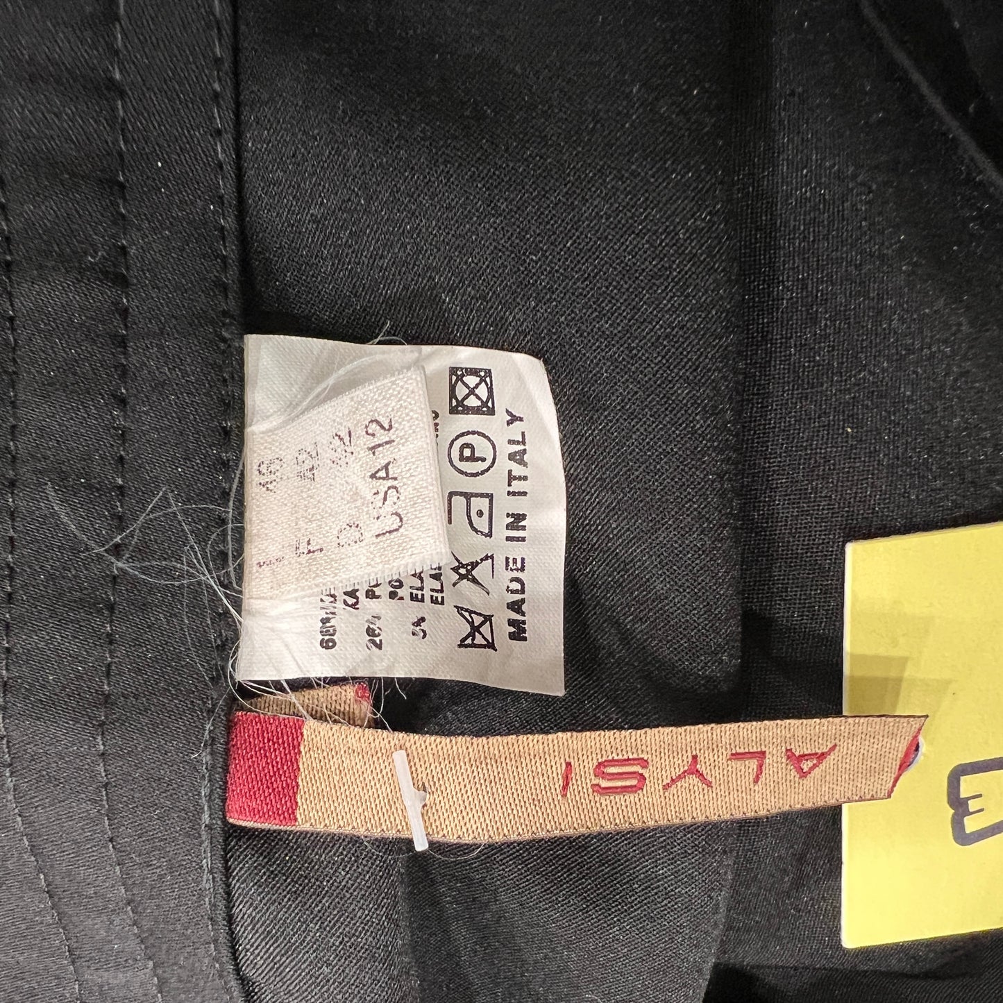 Close-up of a label on a black garment with visible text and symbols