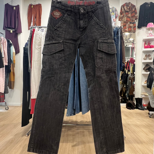 Dark gray cargo pants displayed in a clothing store with various garments in the background