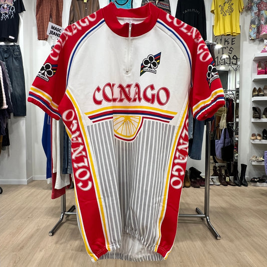 Red and white cycling jersey with 'Colnago' branding in a store setting
