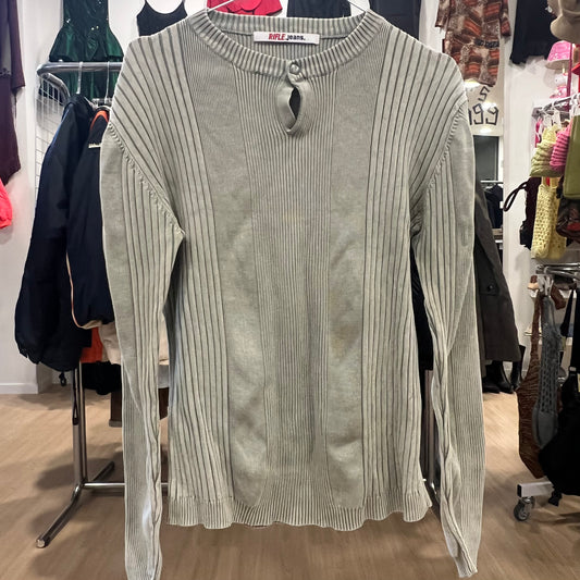 Gray ribbed sweater on a rack with clothing in the background