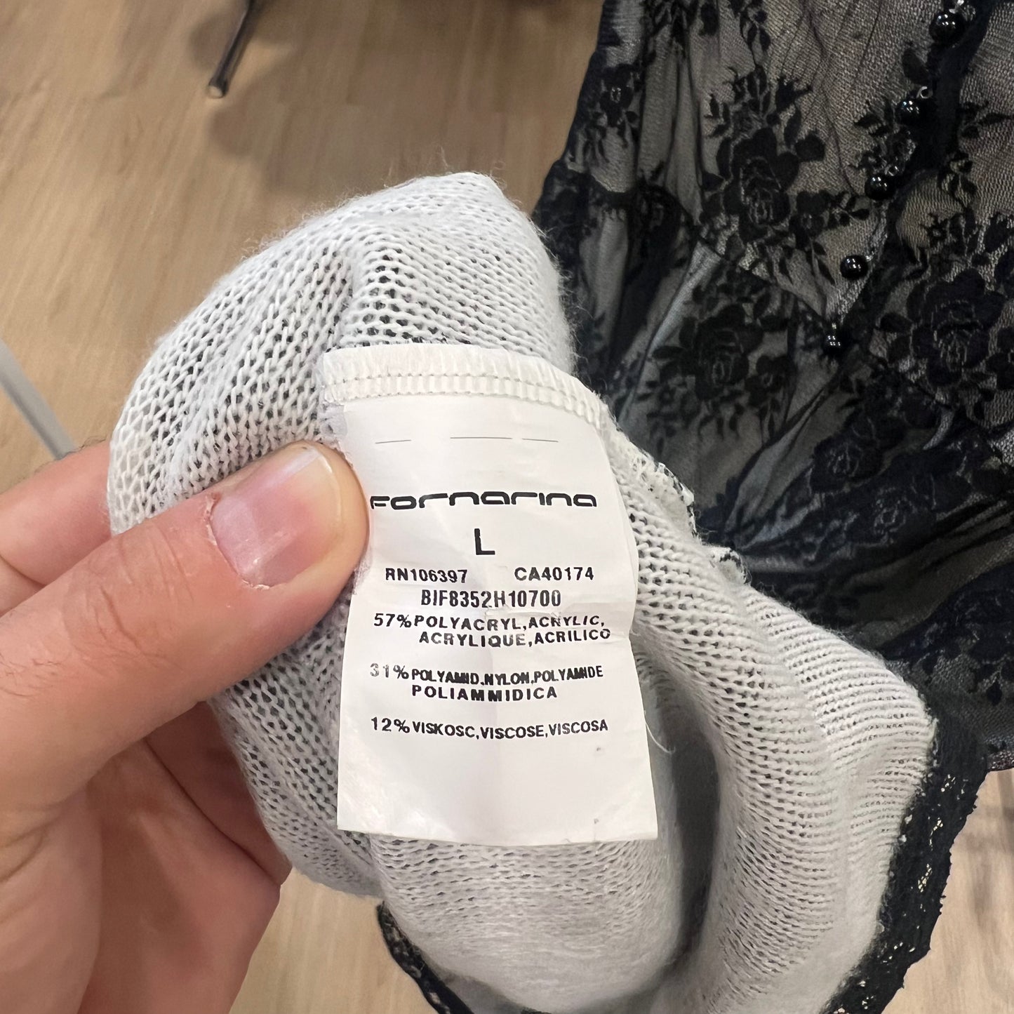 White label held by a hand on a wooden floor