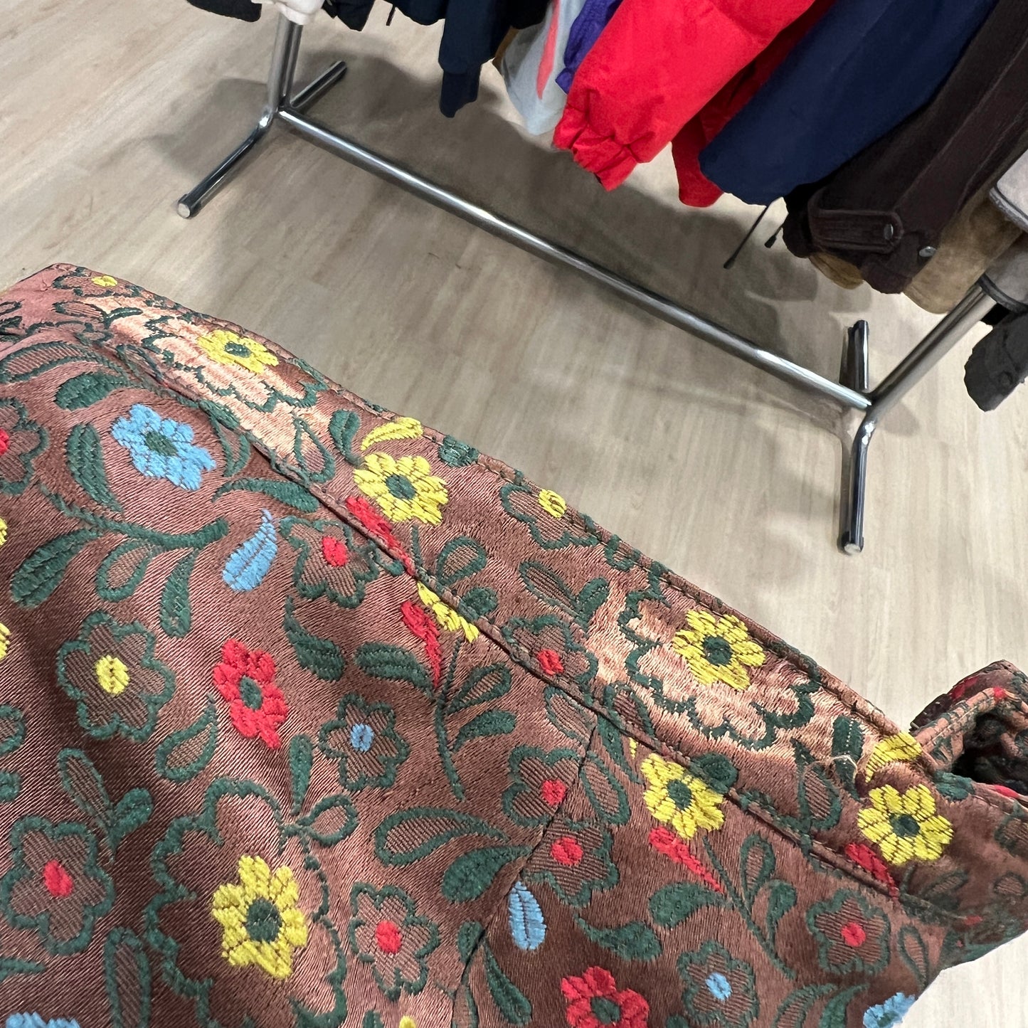 Floral-patterned fabric with colorful embroidery on a wooden floor