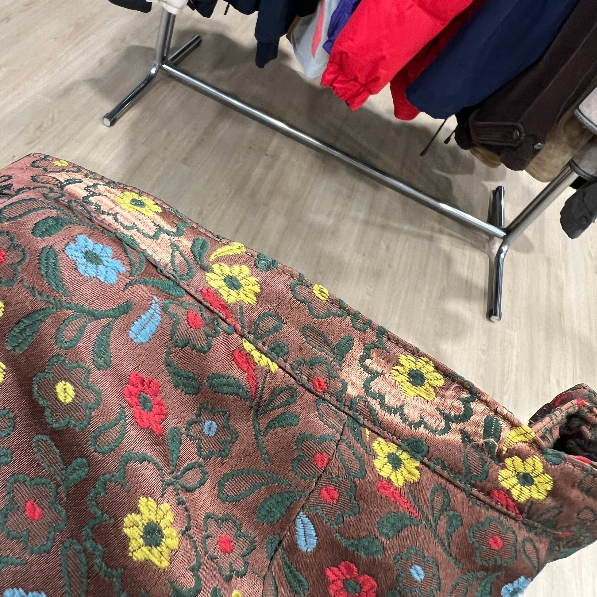 Floral-patterned fabric with colorful embroidery on a wooden floor