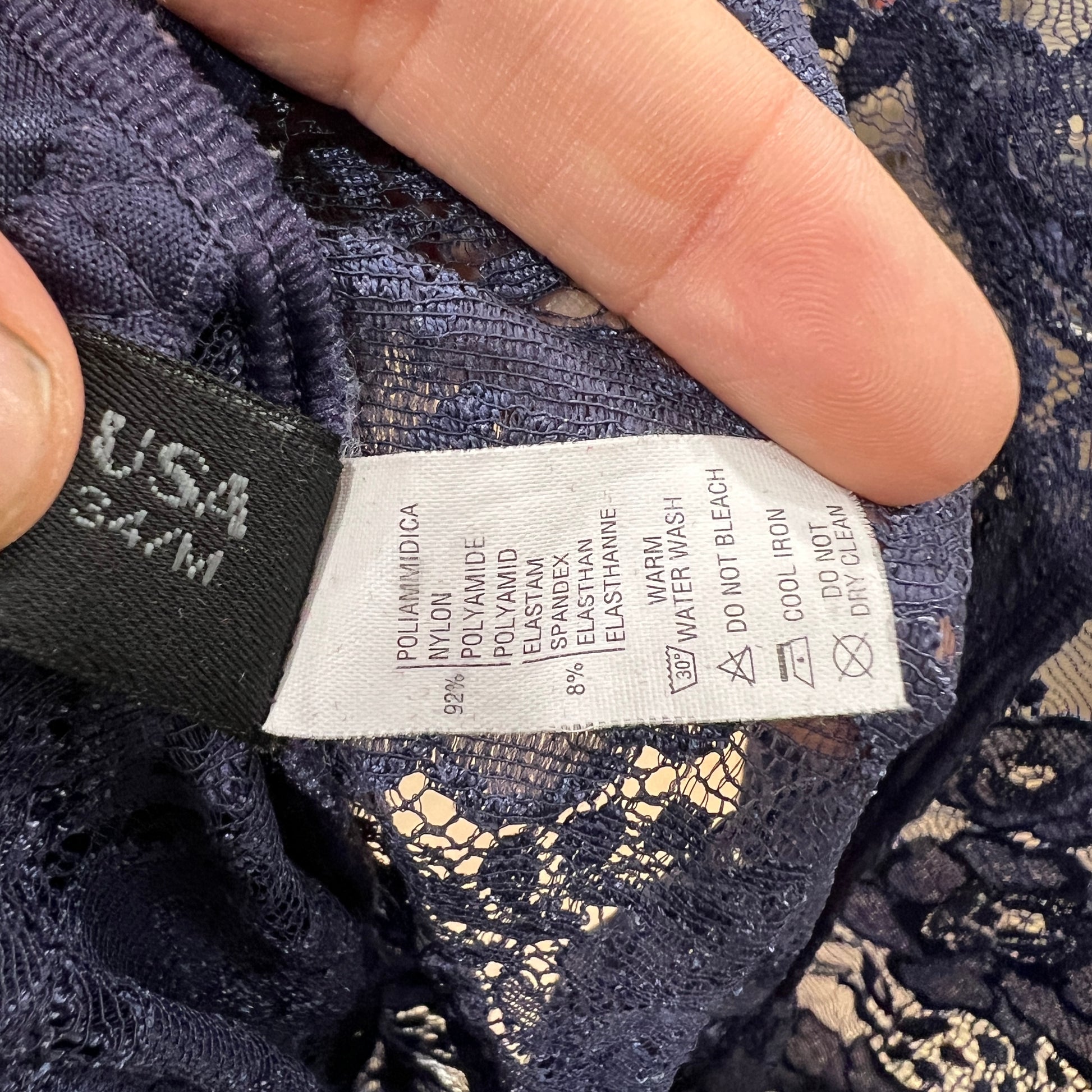 Close-up of a lace garment with a label showing fabric composition and care instructions