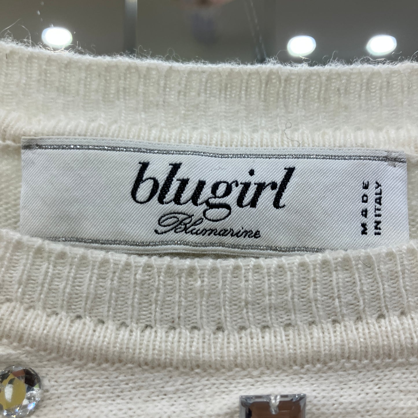 Close-up of a 'blugirl' label on a textured fabric background