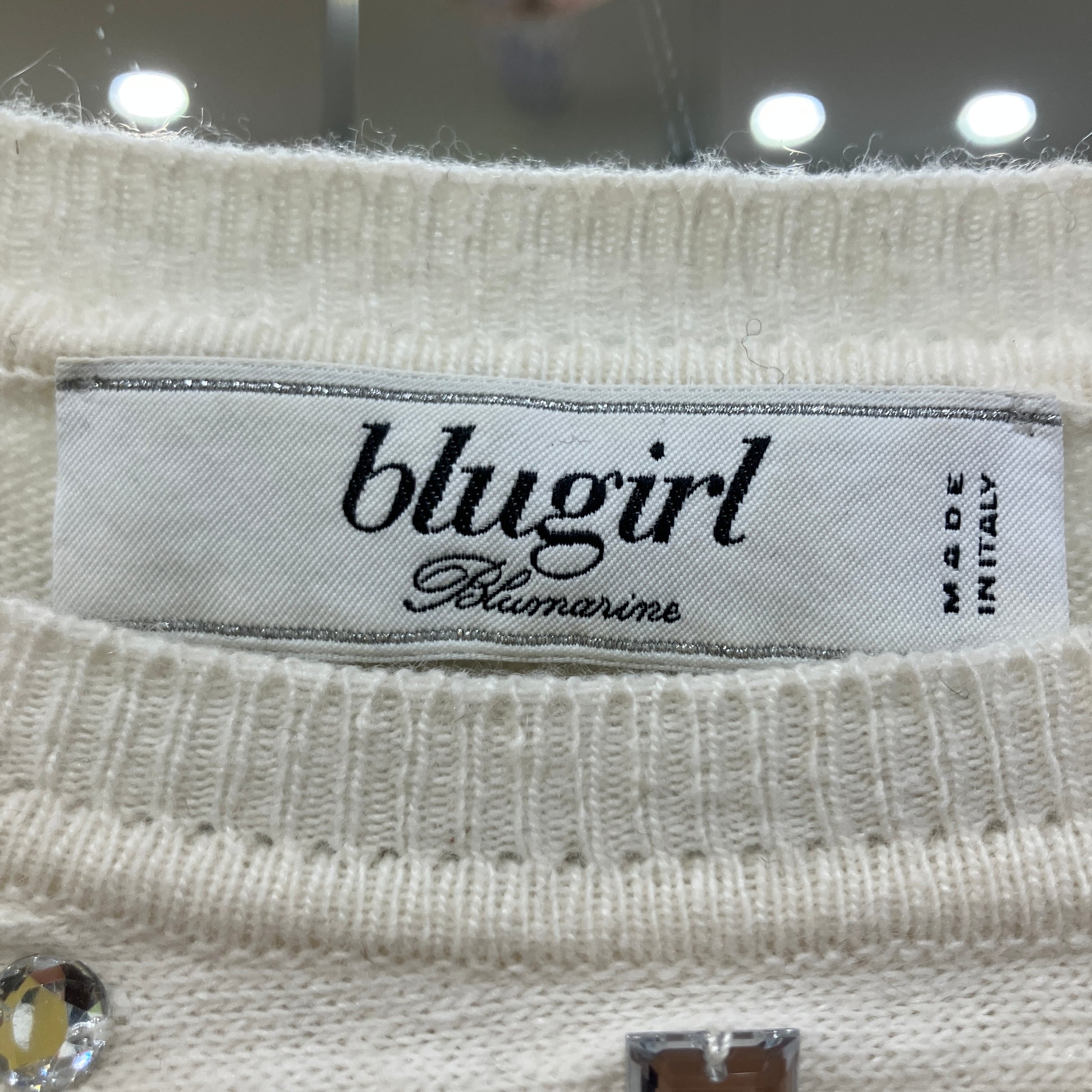 Close-up of a 'blugirl' label on a textured fabric background