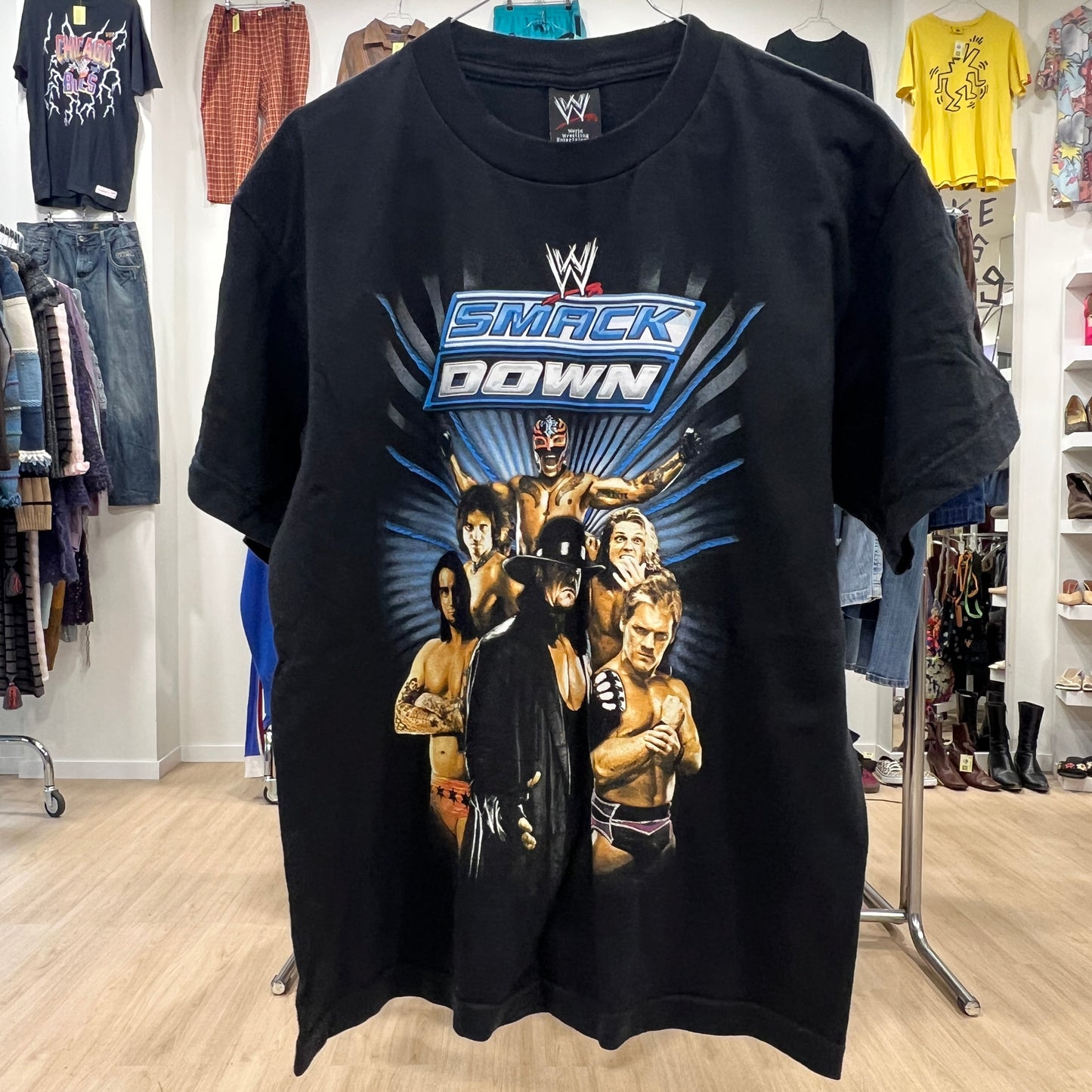 Black t-shirt with WWE SmackDown graphic in a store setting