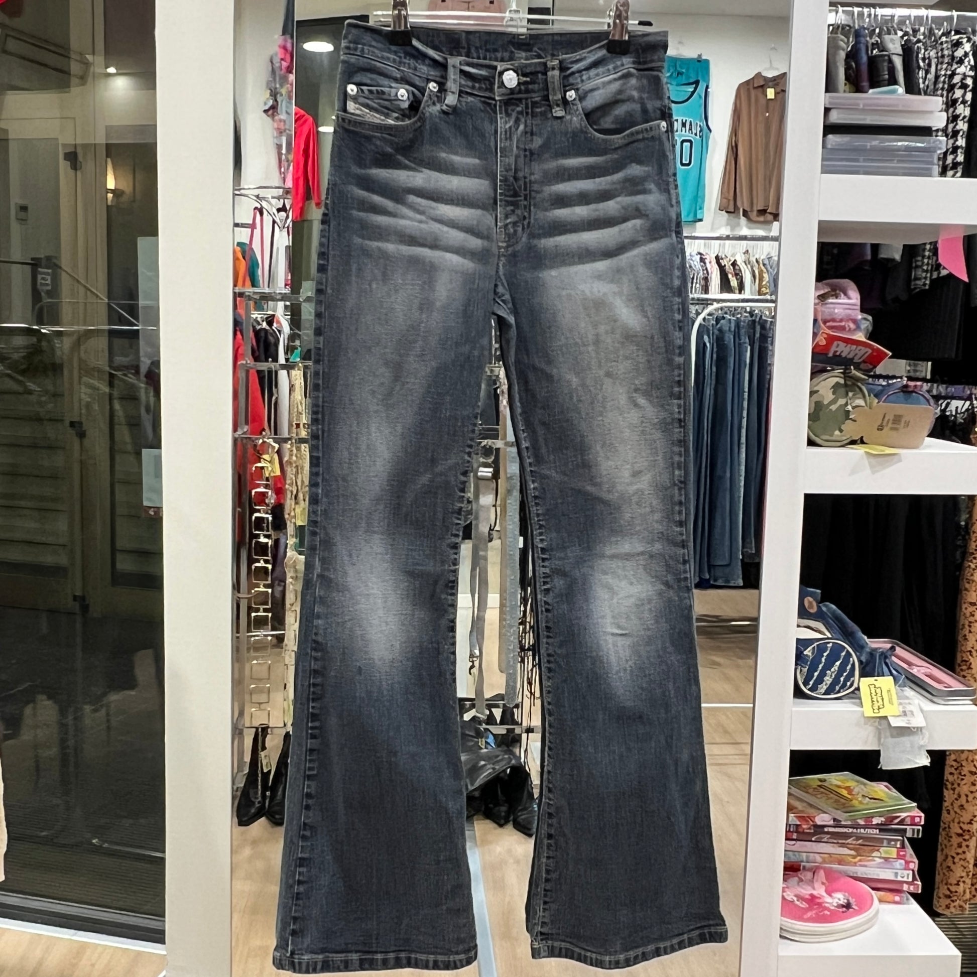Black jeans hanging in a store with various items in the background