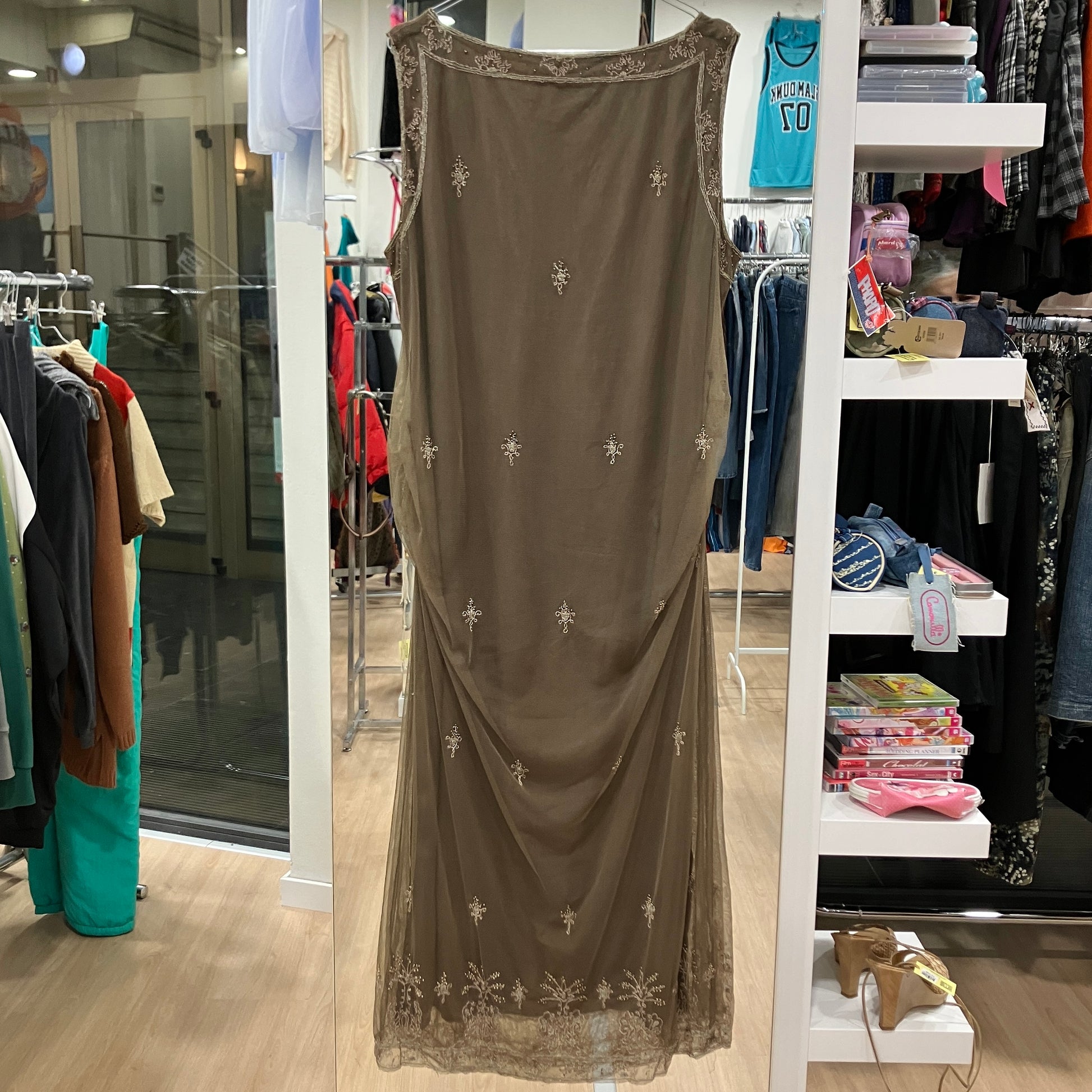 Long brown dress with floral patterns on a rack in a store setting