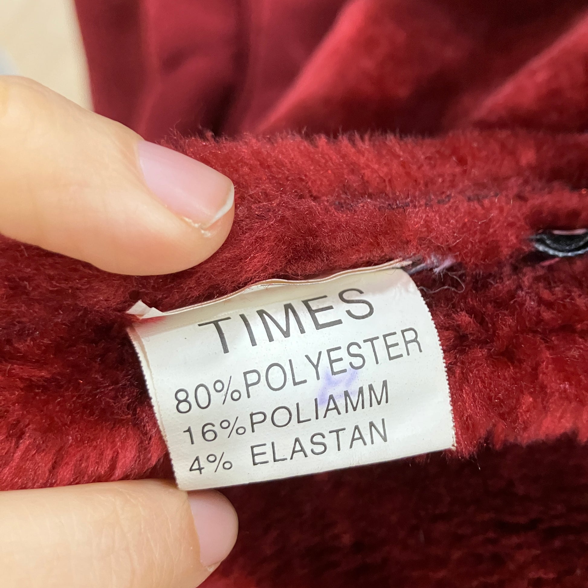 Fabric label on a red garment with material composition details