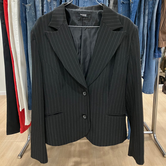 Black pinstripe blazer on a rack with other clothing items in the background