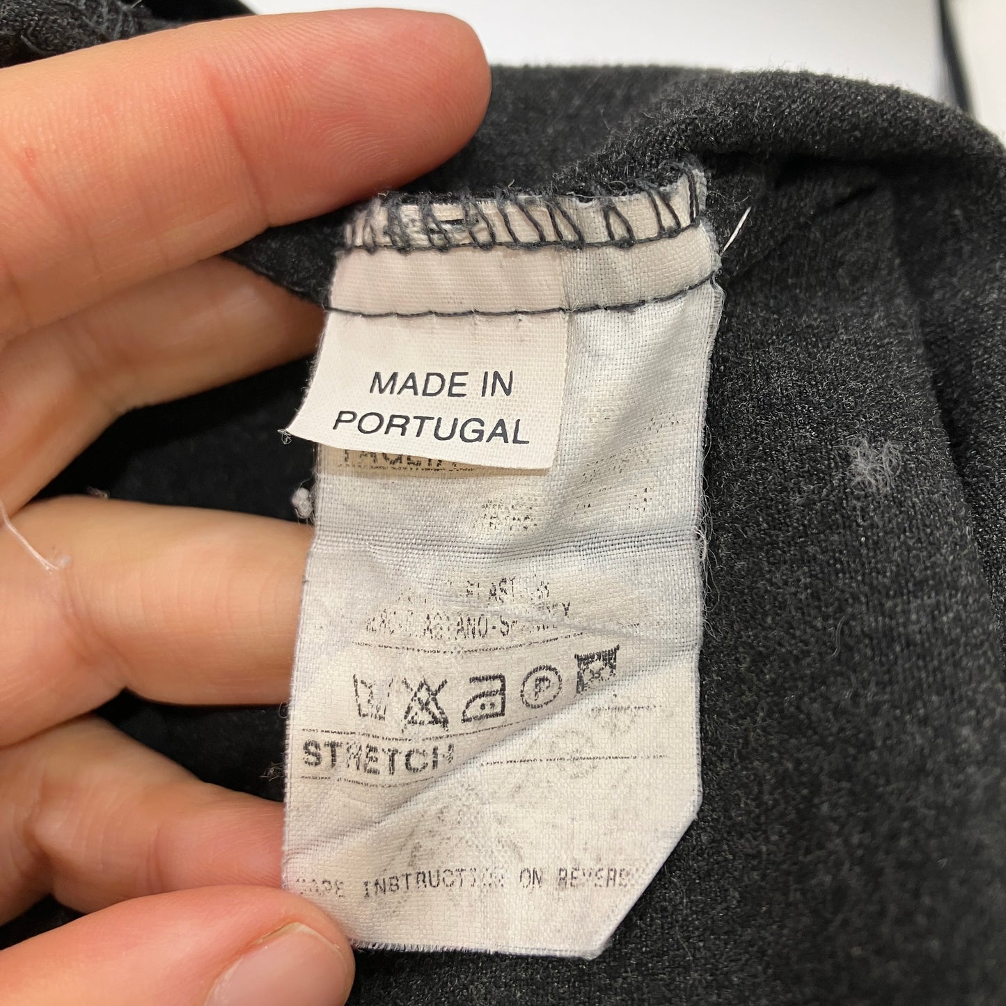 Fabric tag on a garment with 'Made in Portugal' text