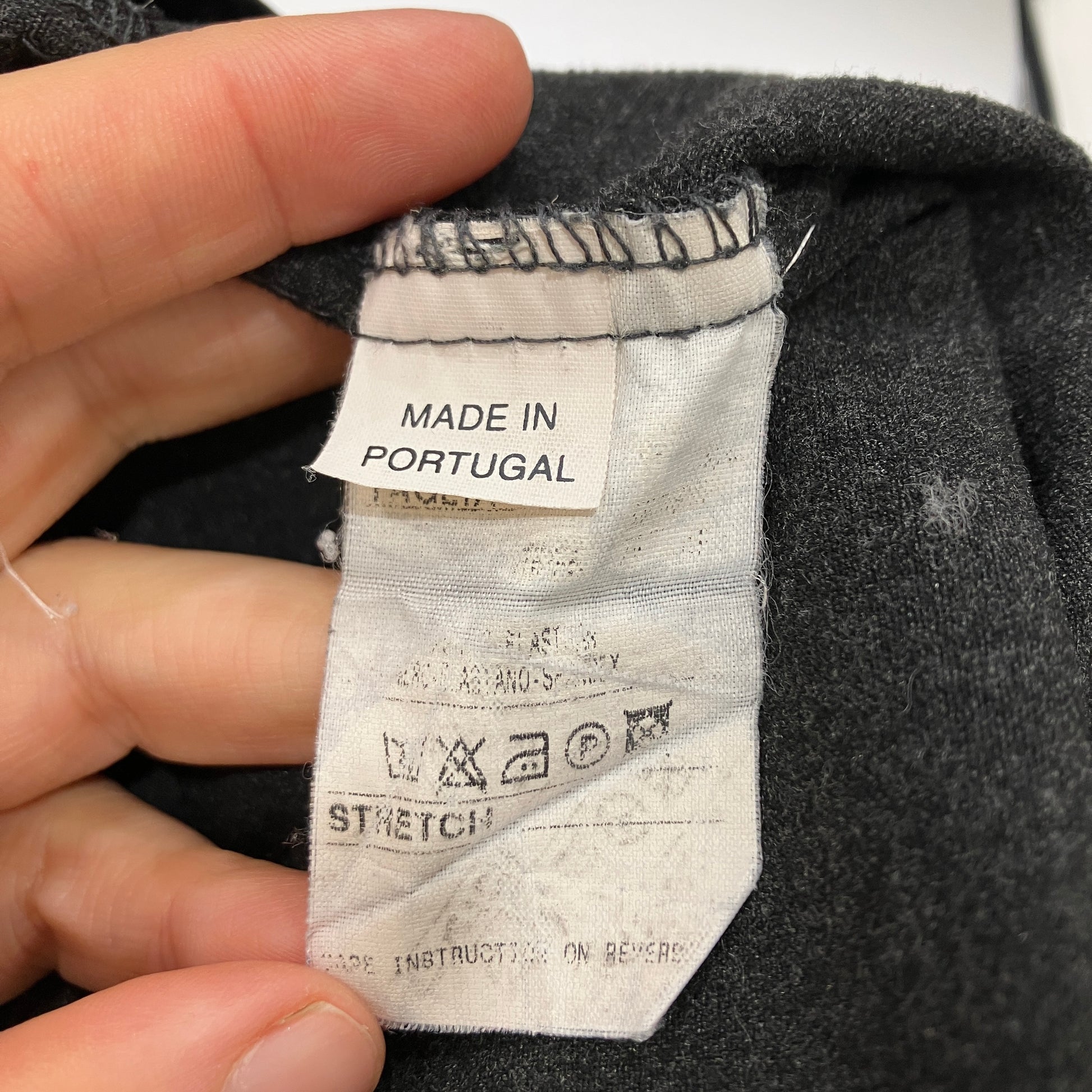 Fabric tag on a garment with 'Made in Portugal' text