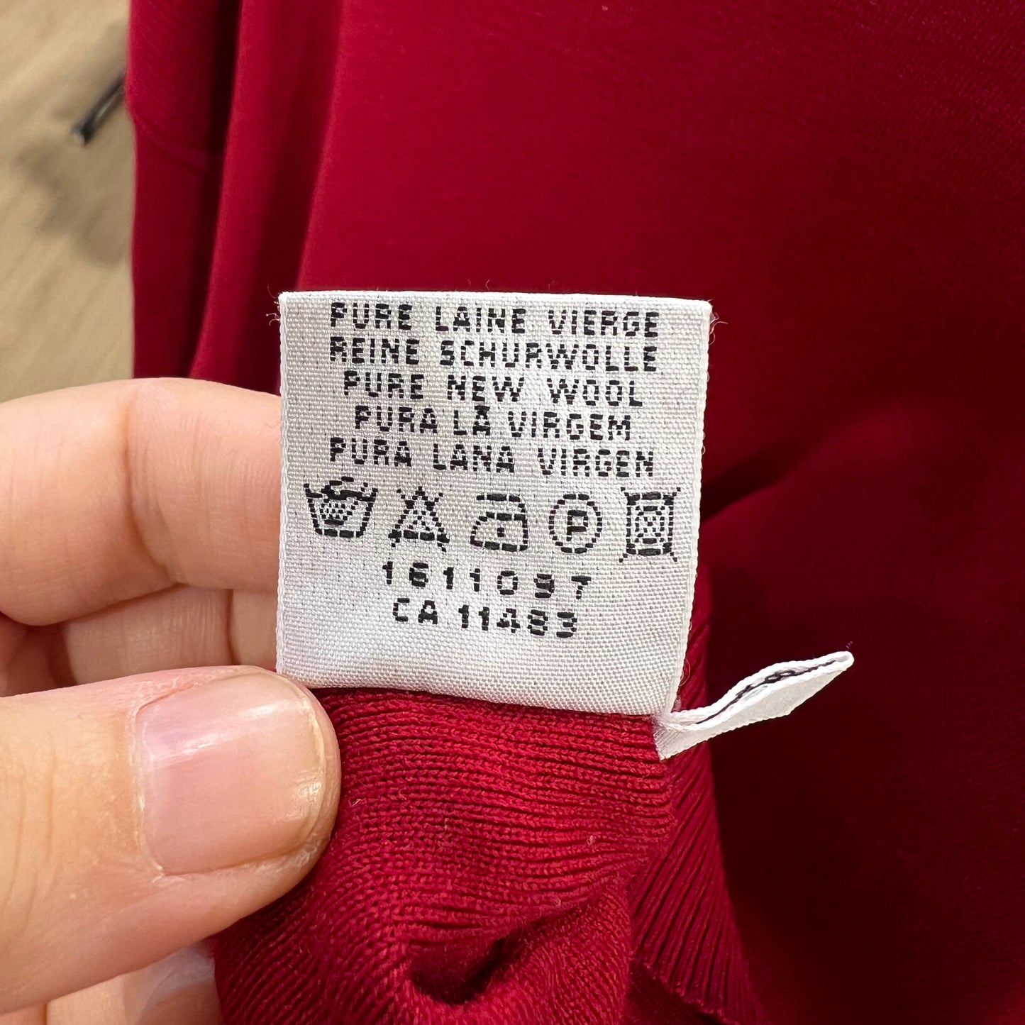 Clothing label on a red garment with text and symbols