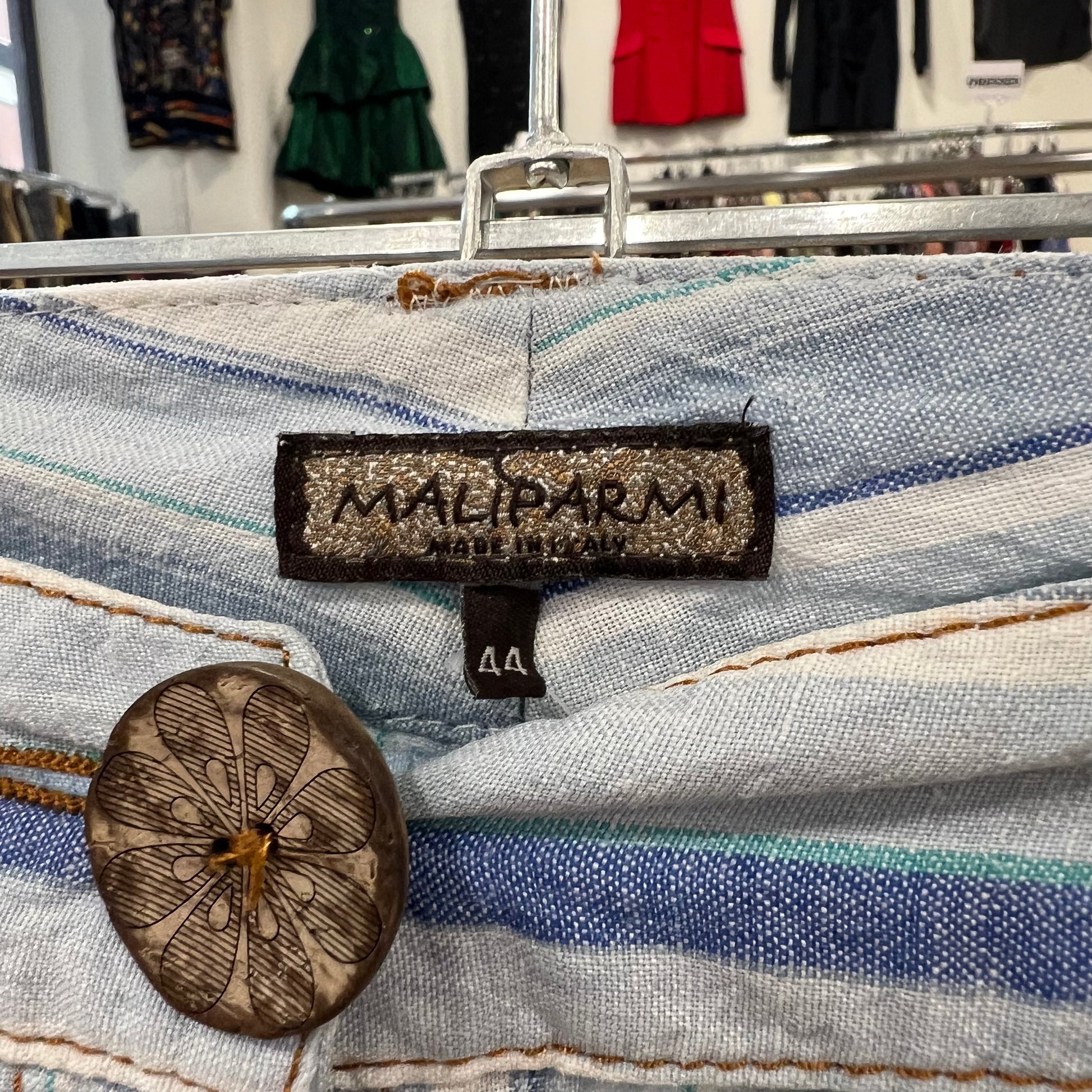Striped fabric with a Maliparmi label and button in a clothing store setting