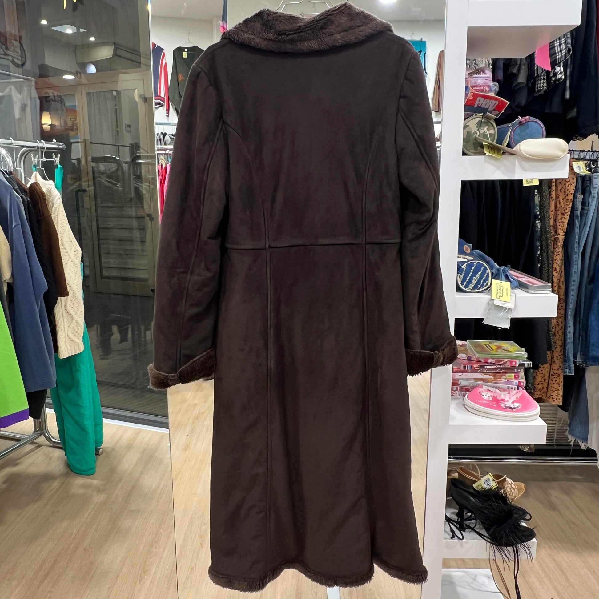 Brown coat with fur collar on a rack in a store setting