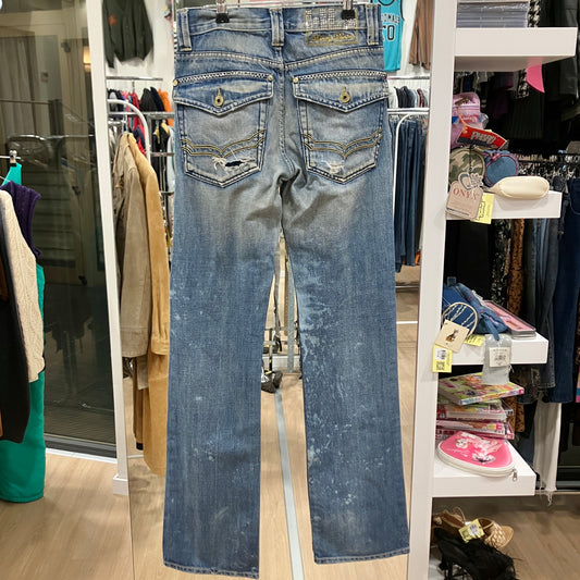 Blue jeans displayed on a rack in a store setting with various items and clothing in the background