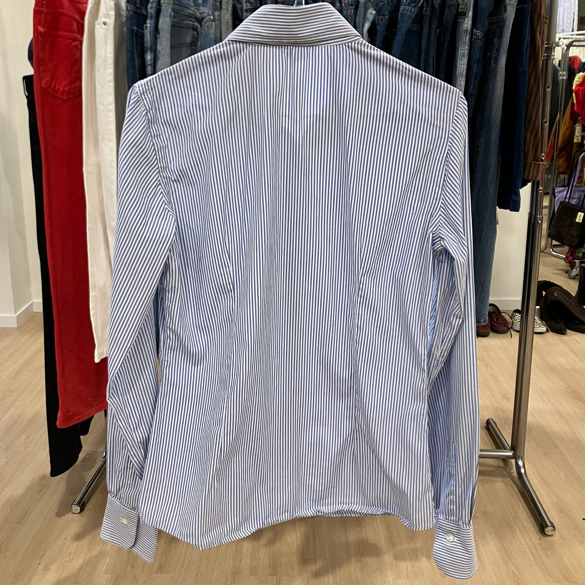 Blue and white striped shirt on a hanger in a clothing store
