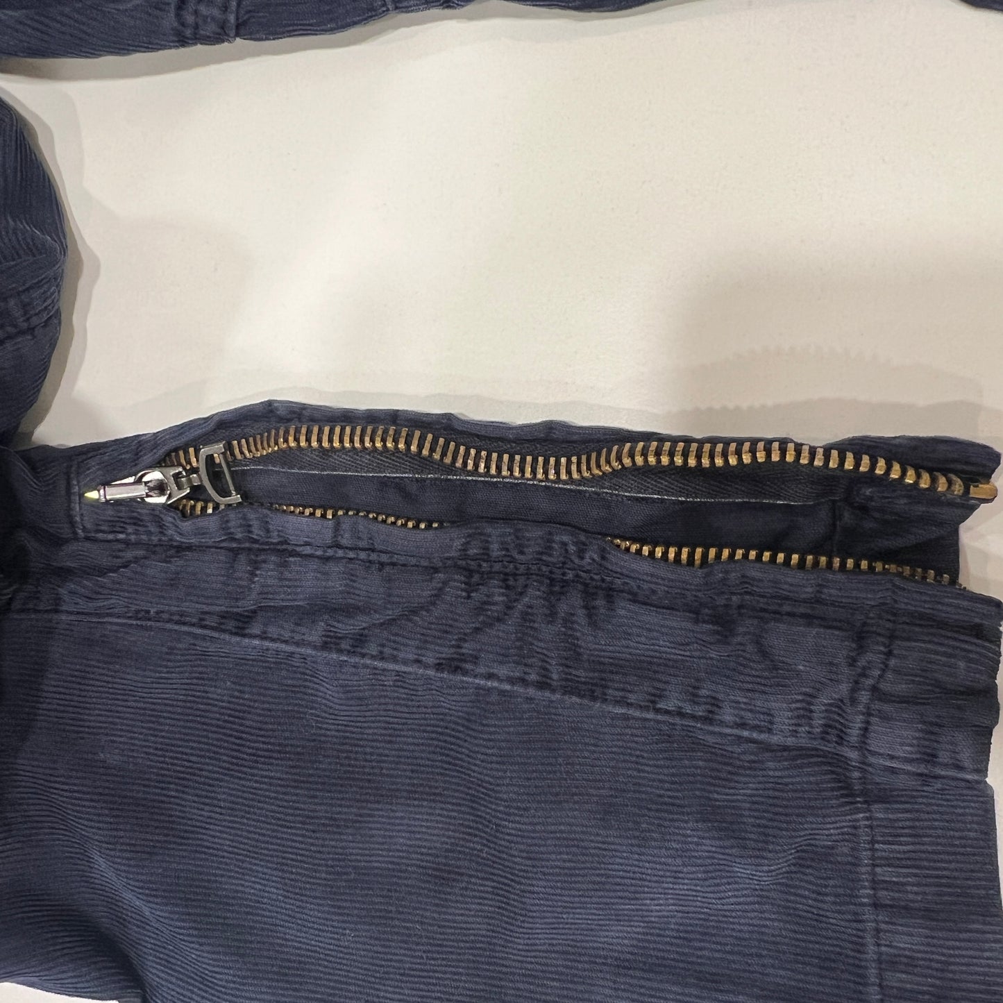 Close-up of blue corduroy pants with a zipper on a white background