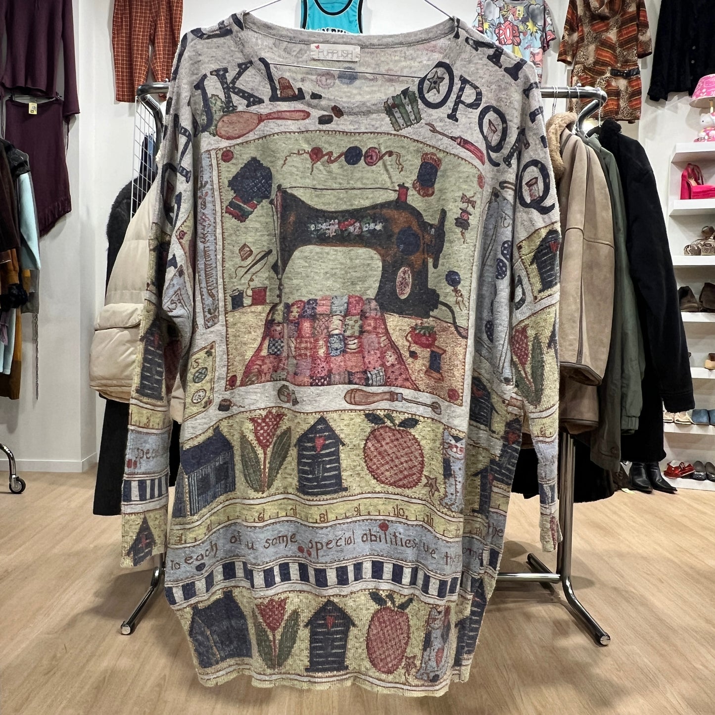 Patterned sweater with sewing machine design on a rack in a store