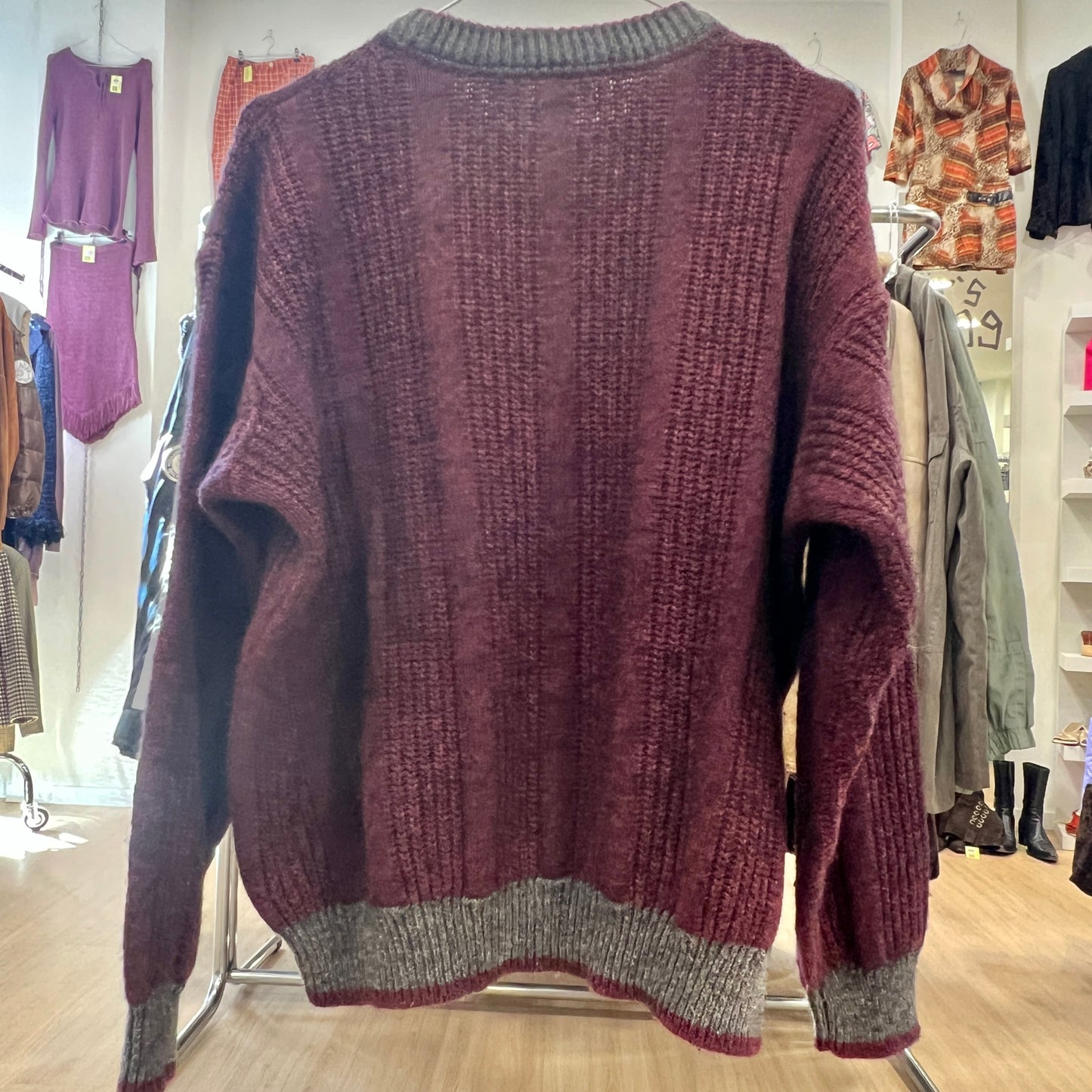 Maroon sweater on a rack in a clothing store