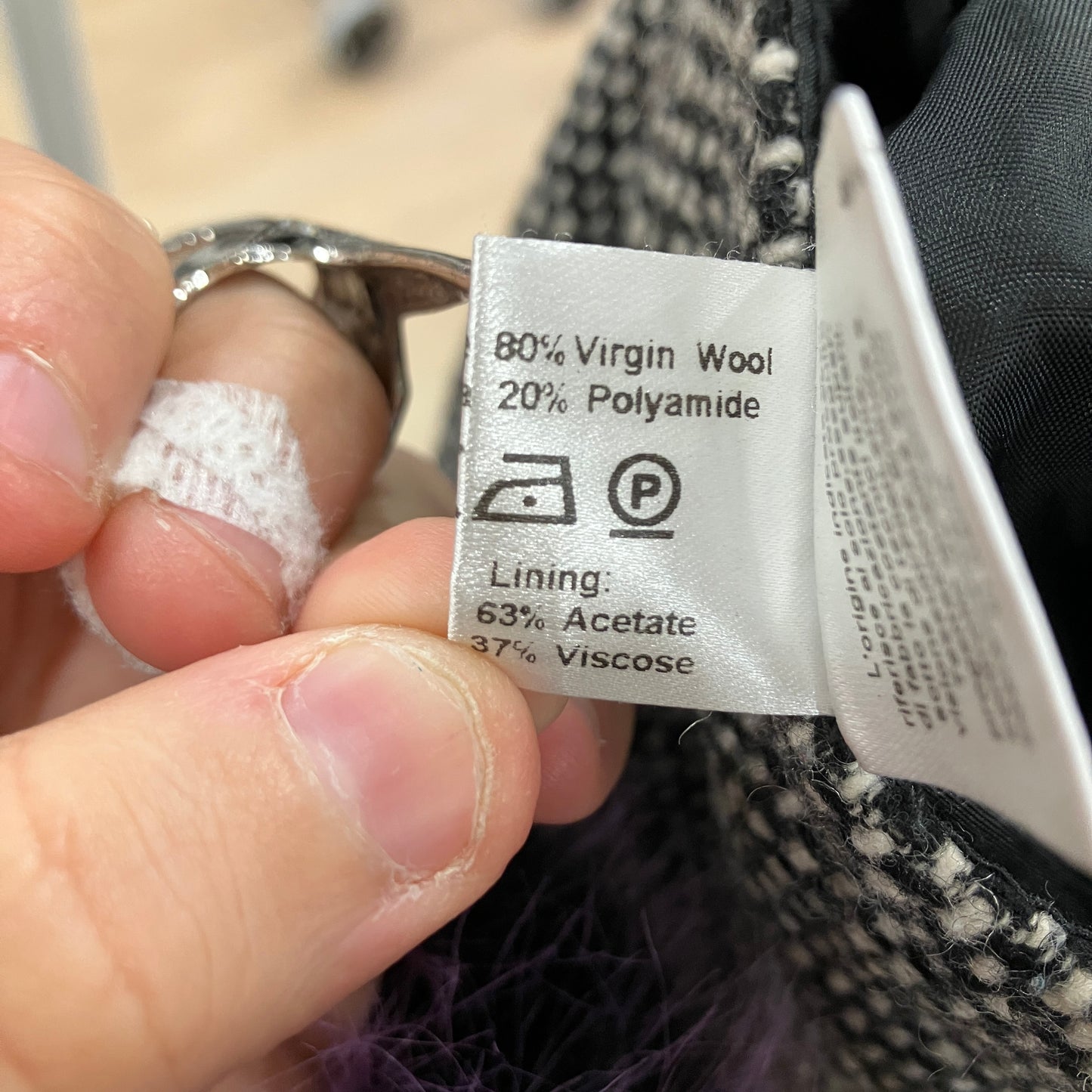 Clothing label with fabric composition details held by a hand