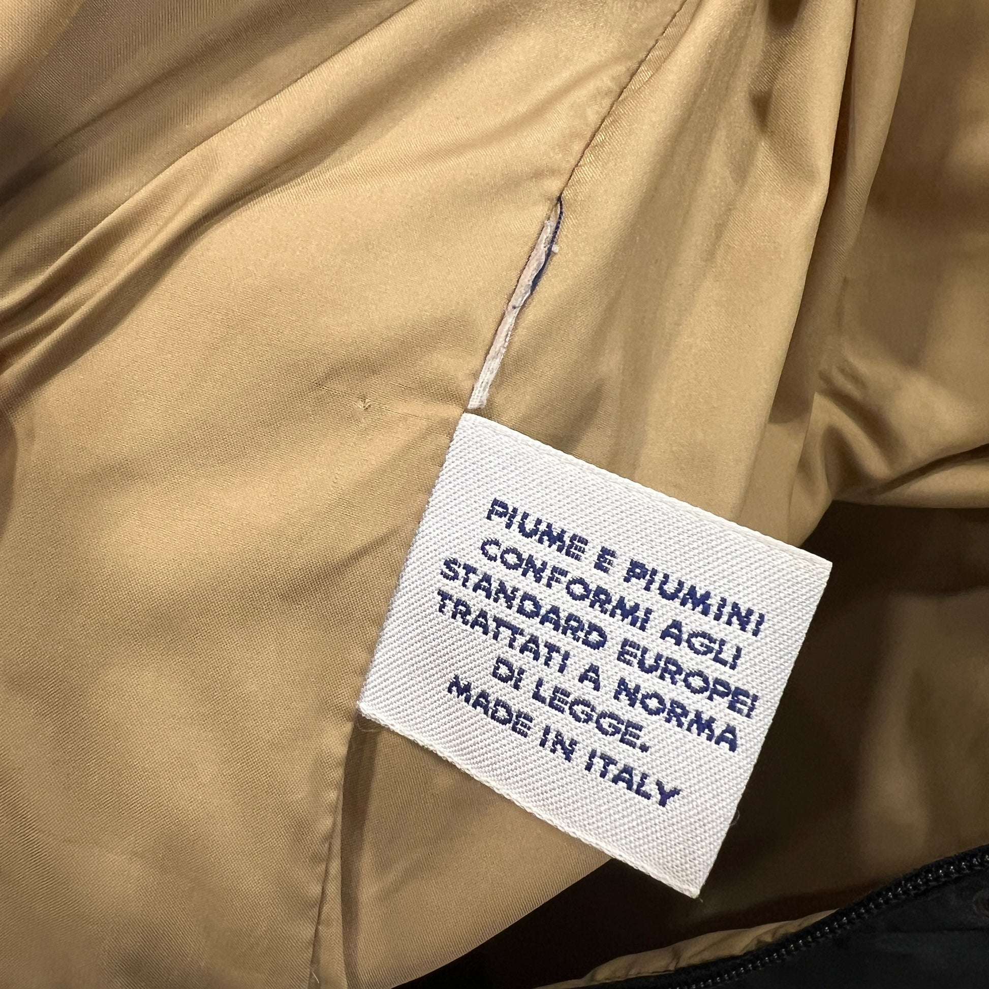 Text label on a beige jacket indicating feather content and manufacturing details