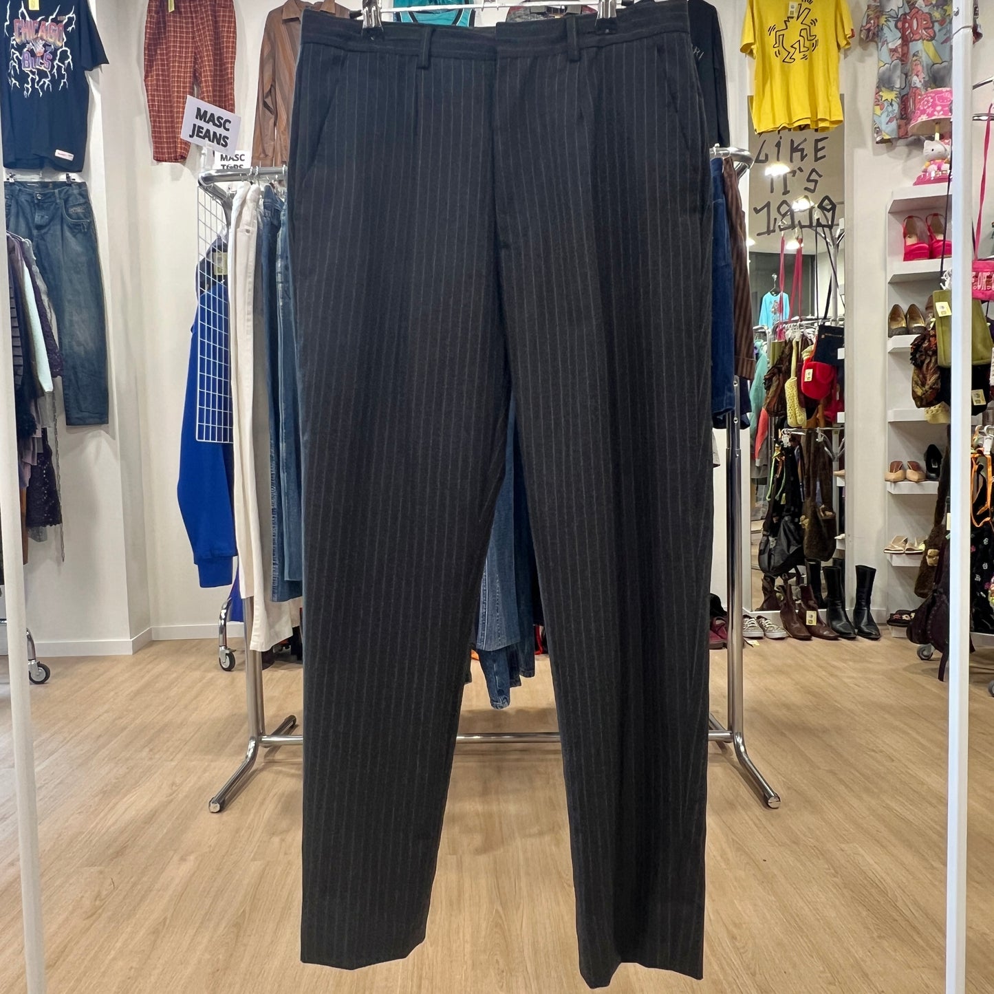 Black pinstripe pants displayed in a clothing store