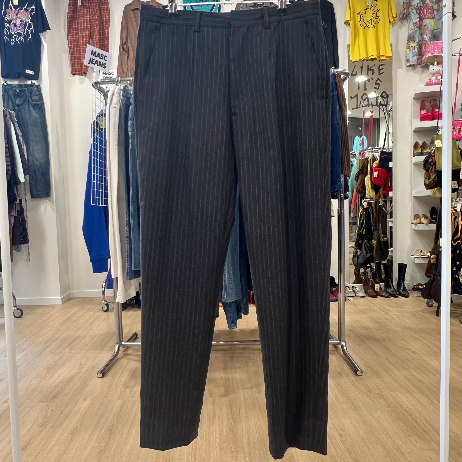 Black pinstripe pants displayed in a clothing store