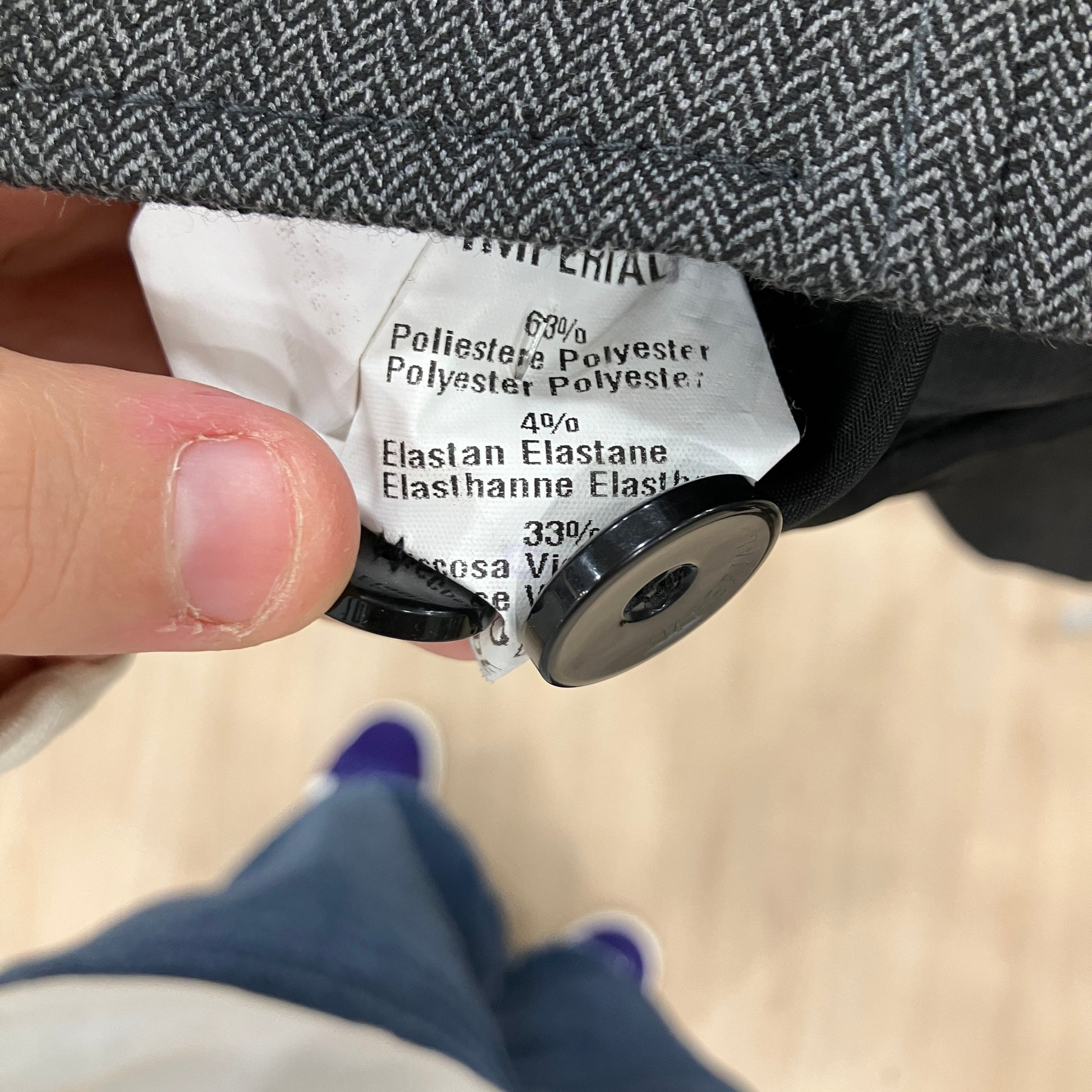 Close-up of a fabric label on a garment with a button
