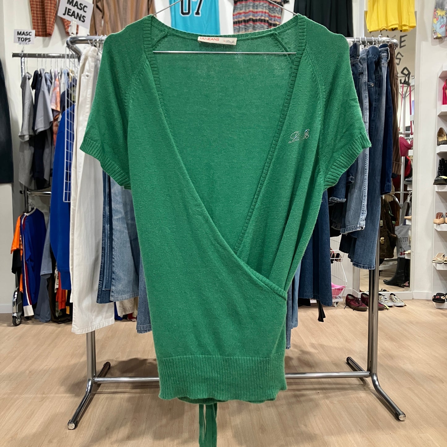Green sweater on a rack in a clothing store