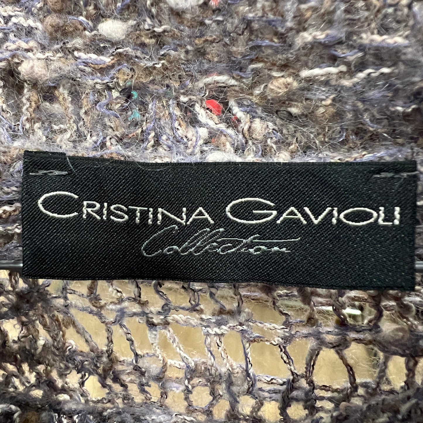 Black label with 'Cristina Gavioli Collection' text on a textured surface