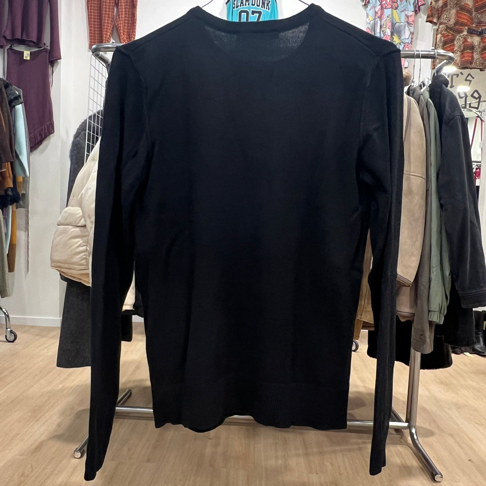 Black long-sleeve shirt on a hanger in a clothing store