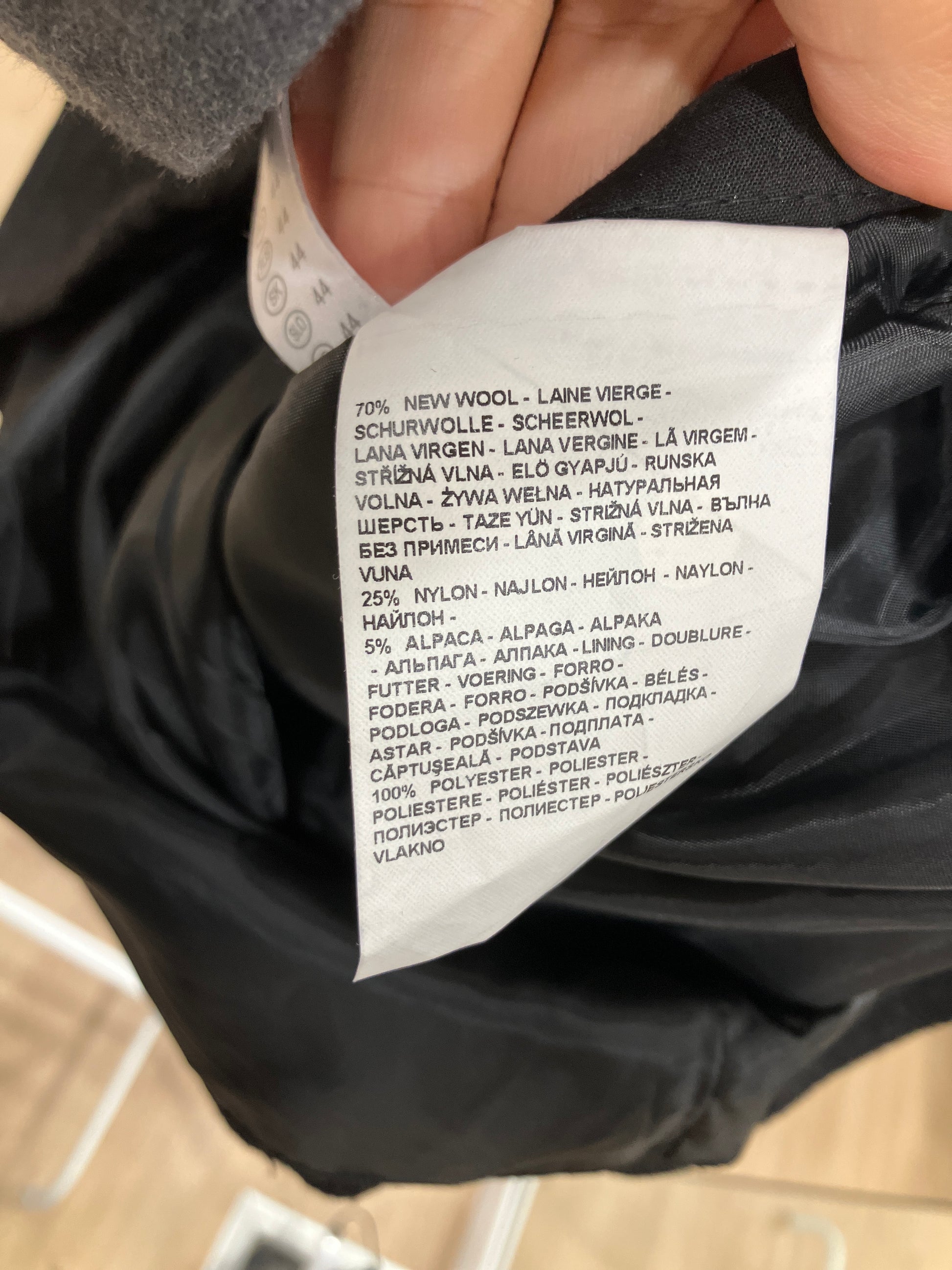 Close-up of a clothing label on a black garment with text