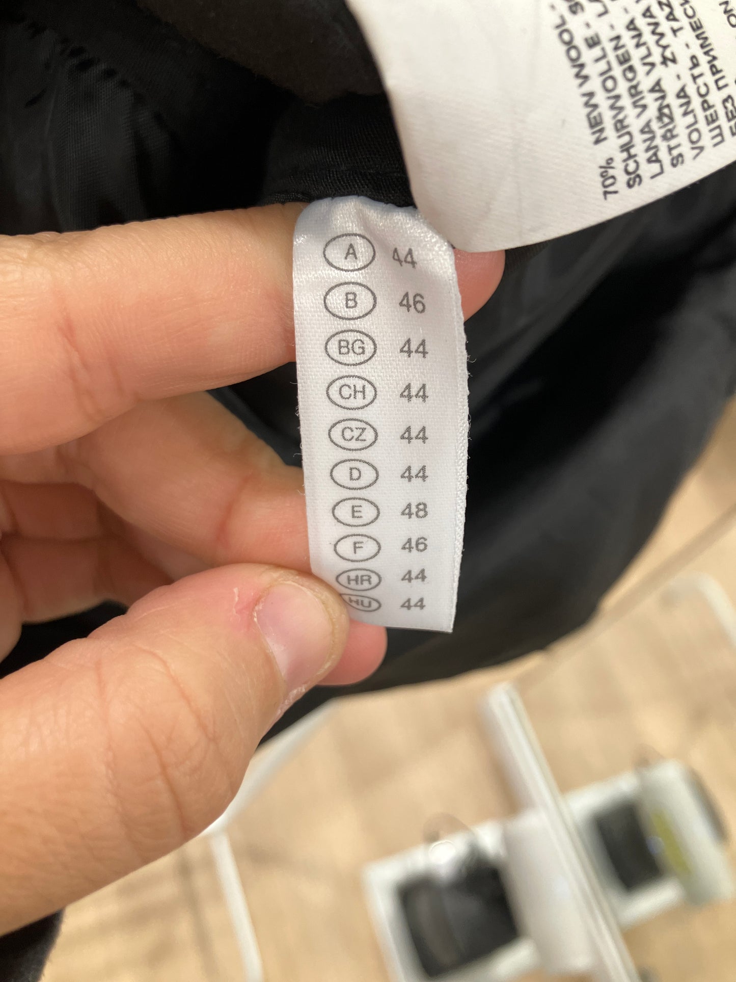 Close-up of a clothing label on a black garment with text