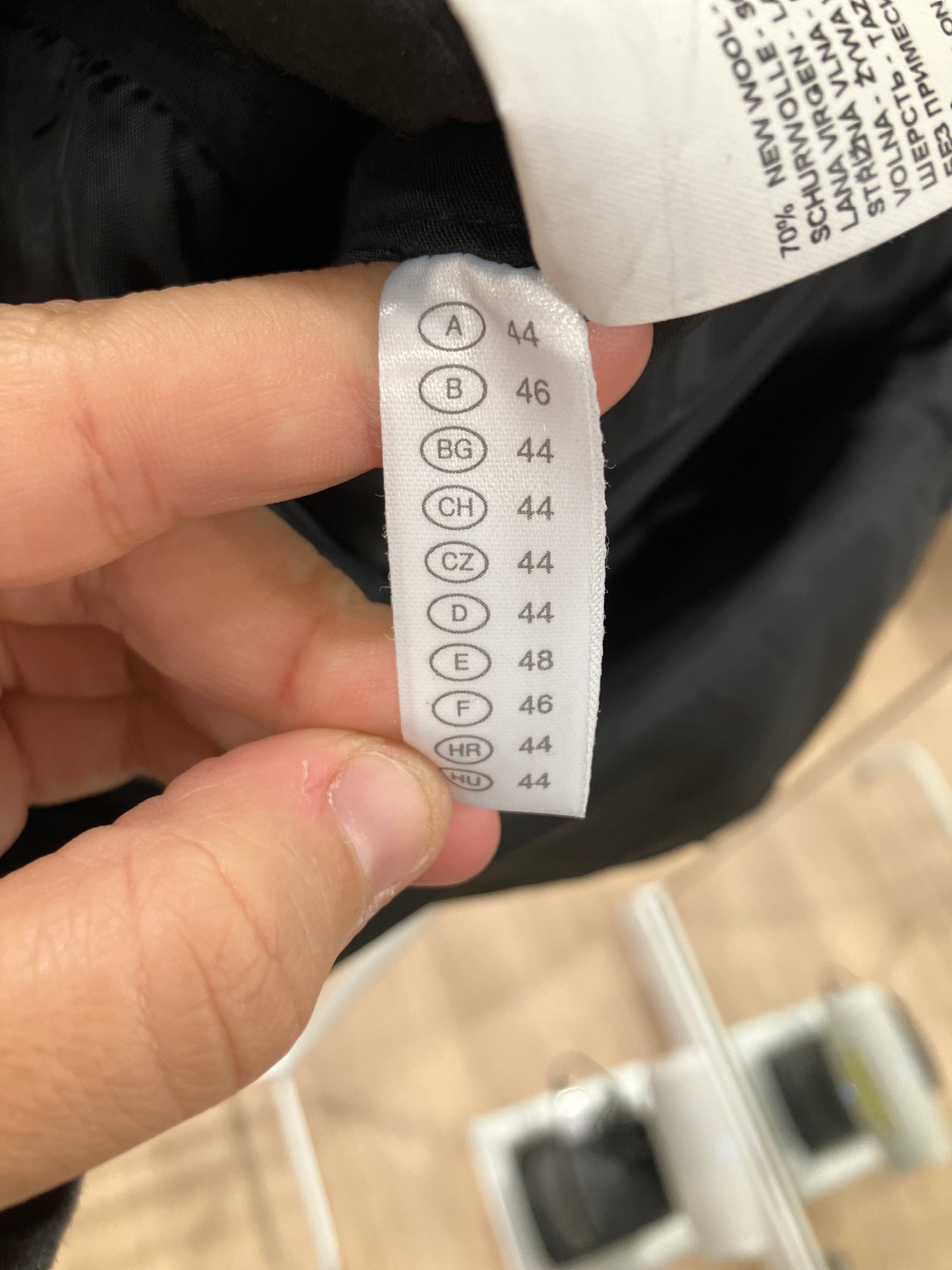 Close-up of a clothing label on a black garment with text