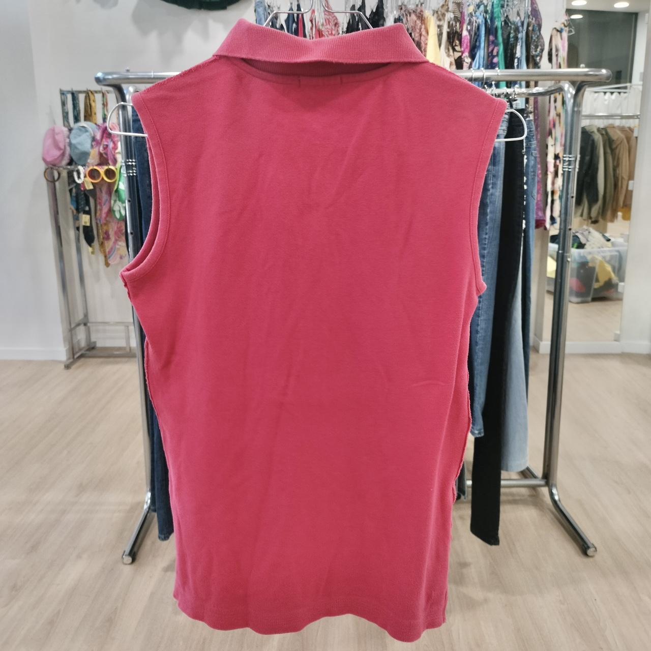 Red sleeveless shirt on a rack in a store setting